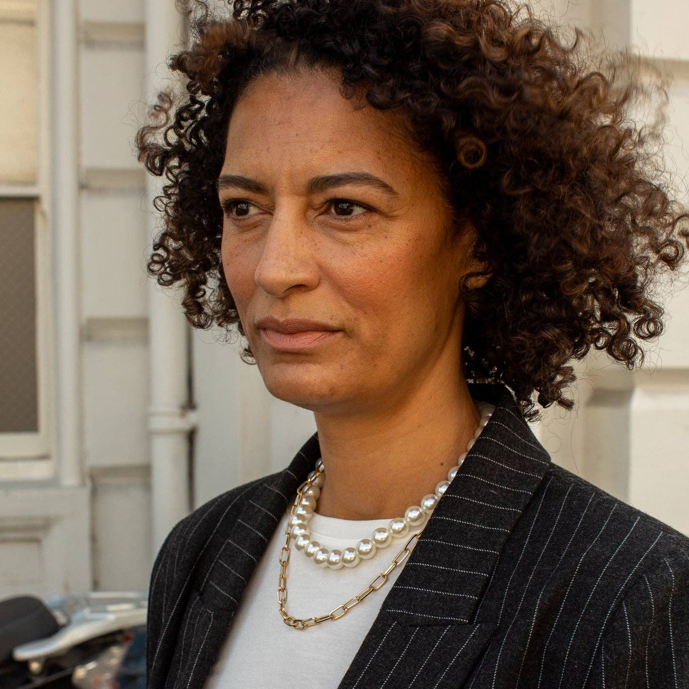 Woman wearing a pinstripe suit with a blurred background