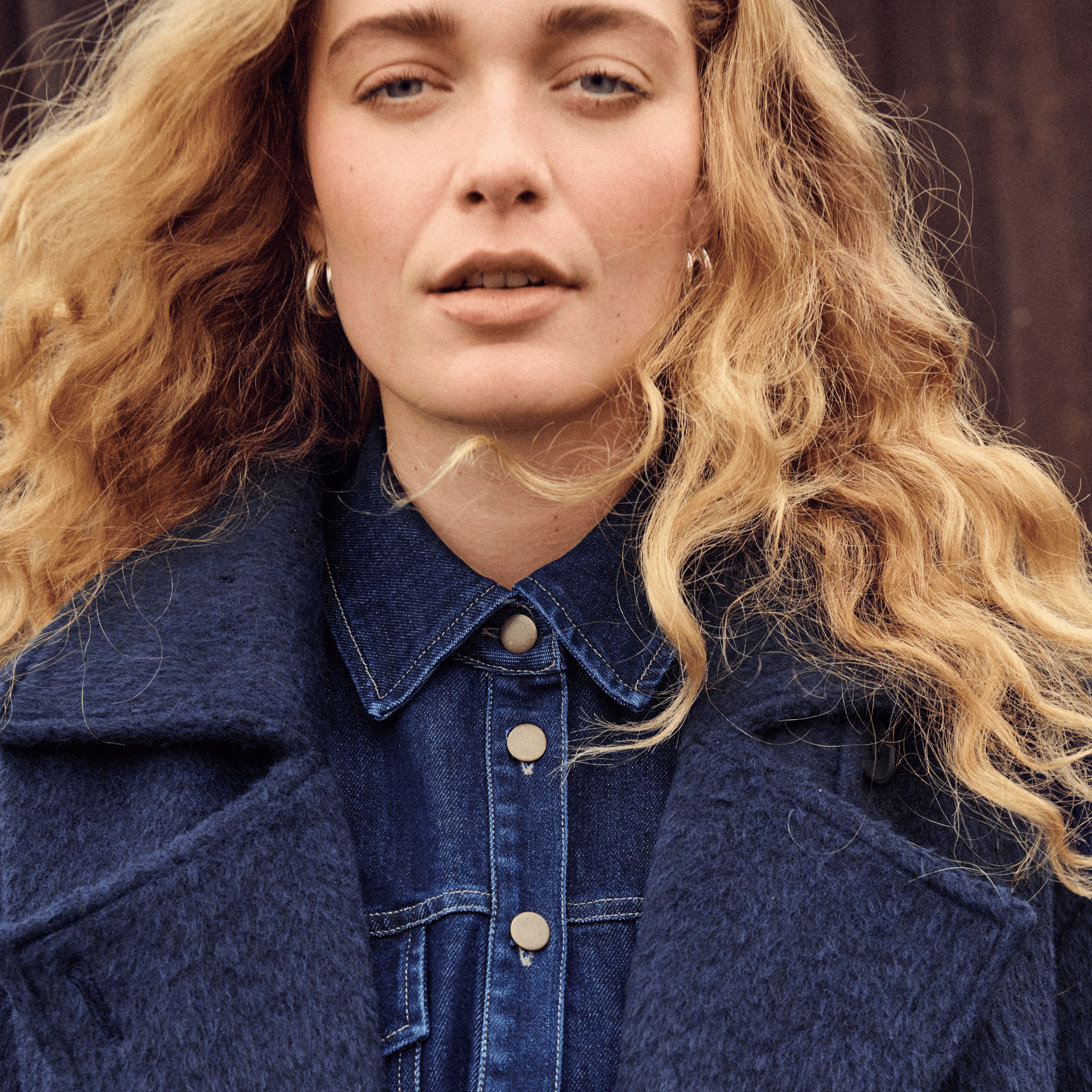 Woman wearing a blue denim shirt and navy wool jacket