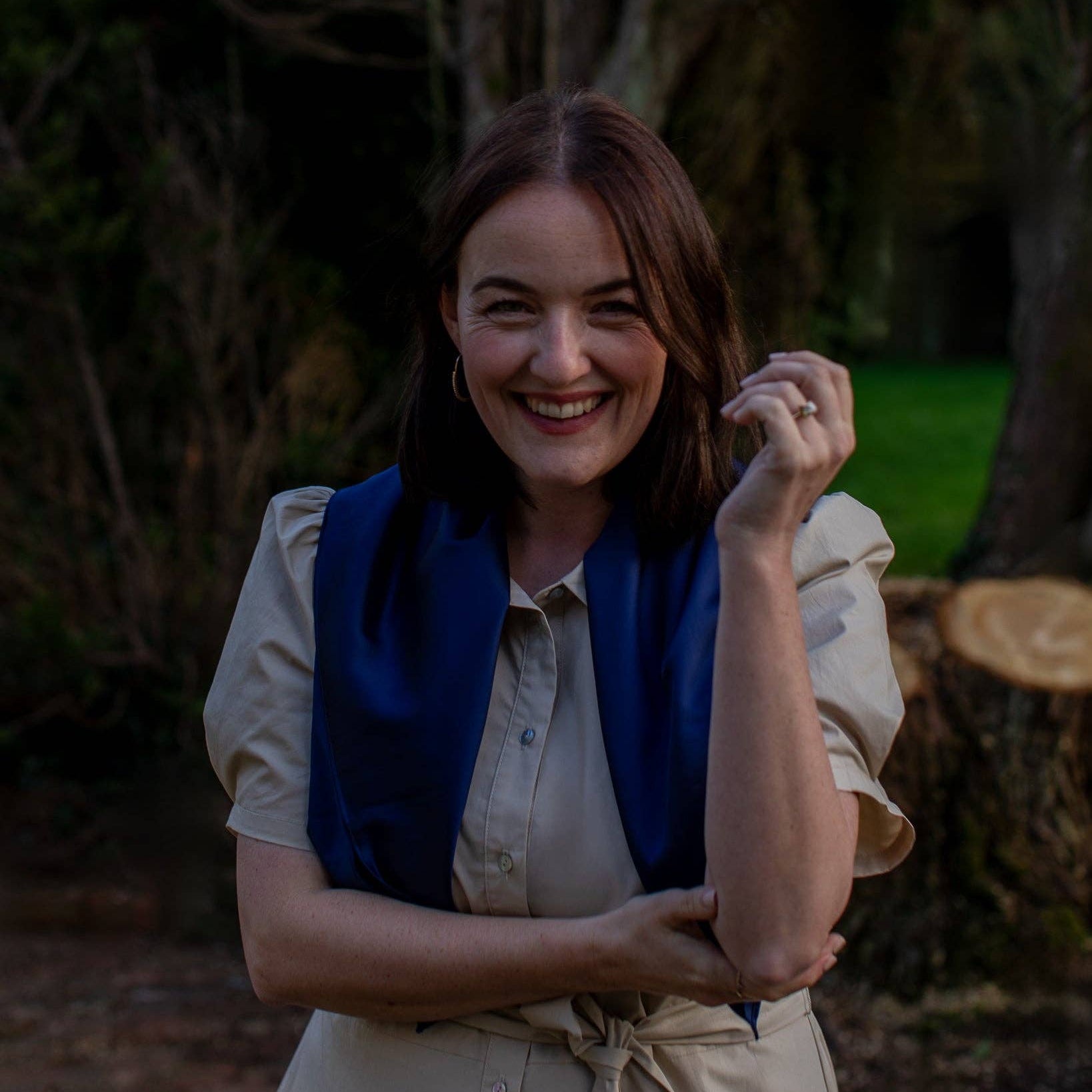 Woman smiling outdoors with a natural background