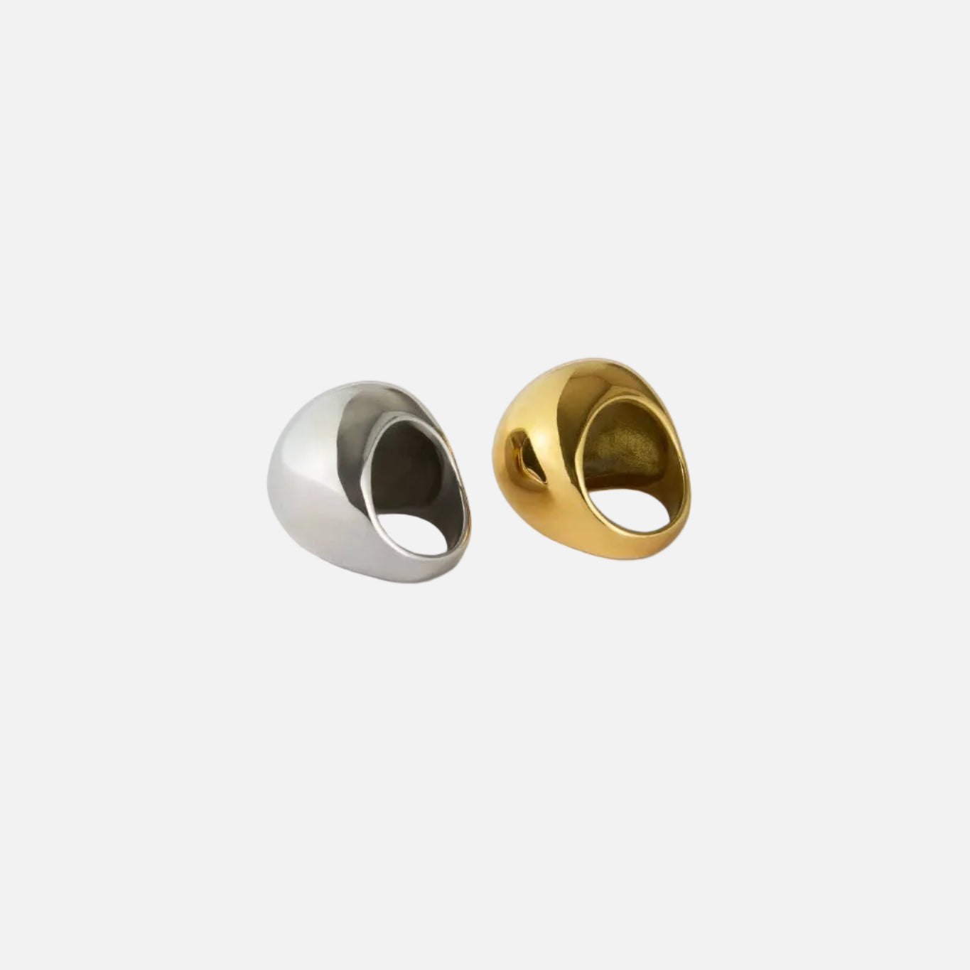 Two metallic rings, one silver and one gold, on a white background