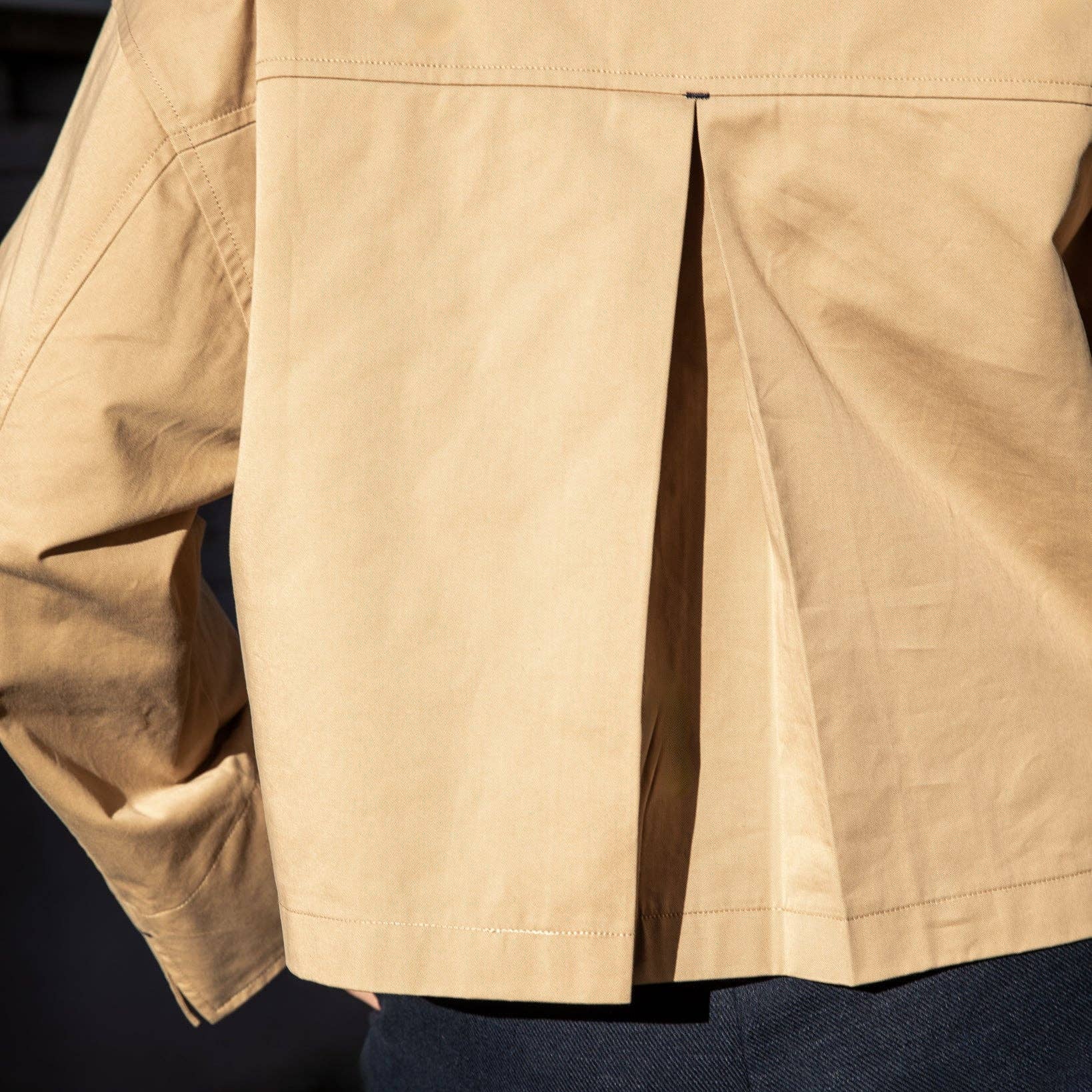 Close-up of a beige jacket with a dark background