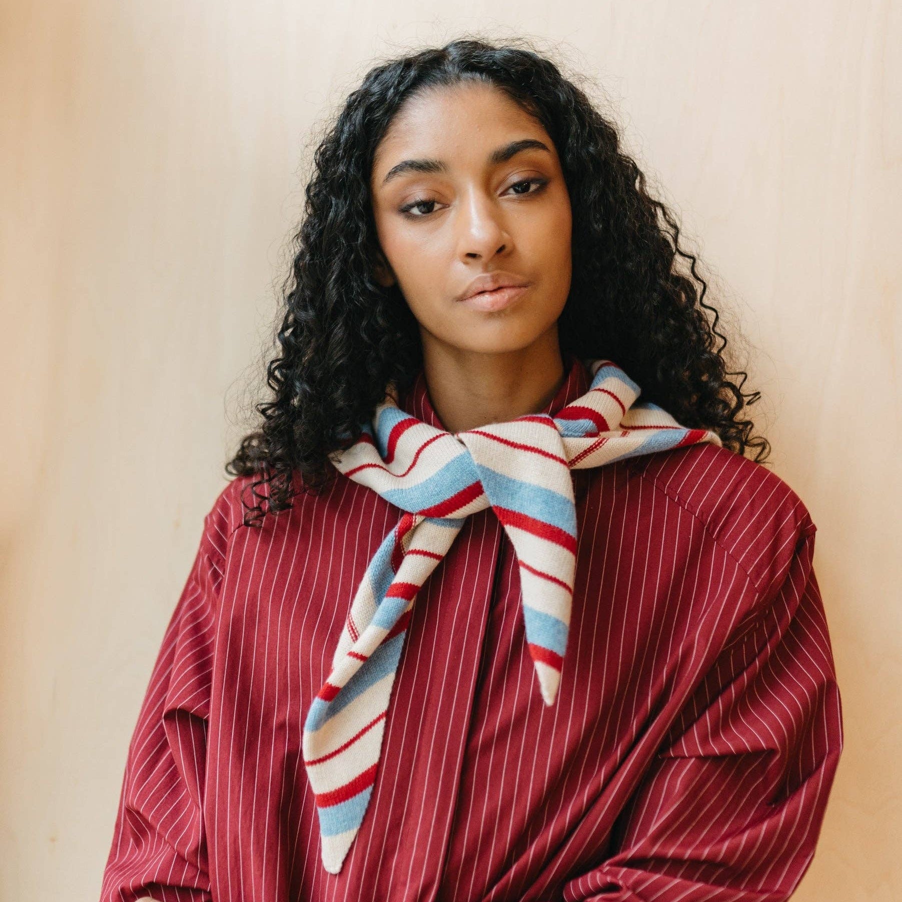 Lady wearing a red, ecru and blue triangle scarf