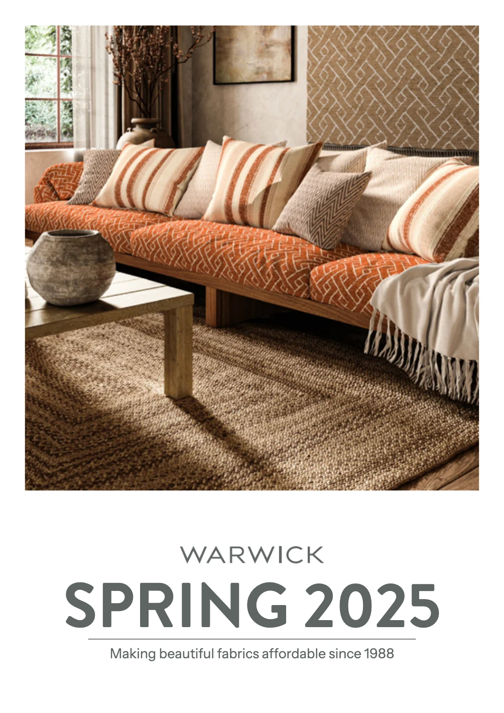 A catalog cover for Warwick Spring 2025, featuring a warm, styled living room scene with an orange patterned sofa, striped pillows, a textured brown rug, and a white throw blanket, with the text 'WARWICK SPRING 2025' below.