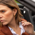 Woman adjusting her jacket inside a car