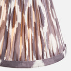 Close-up of a pleated skirt with a patterned design on a white background