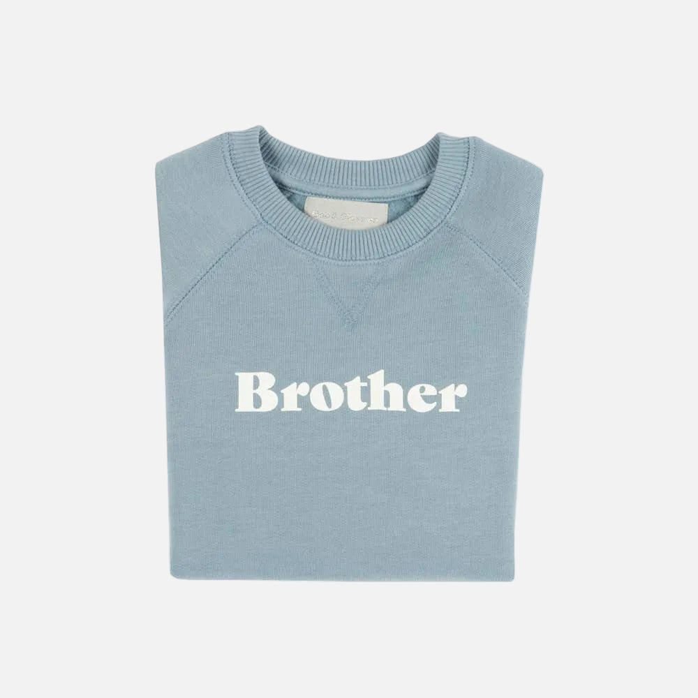 Folded light blue sweatshirt with 'Brother' text on a white background