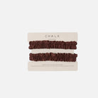 Two dark brown ruffled sleeve garter on a beige card labeled CHALK, photographed on a plain white background.