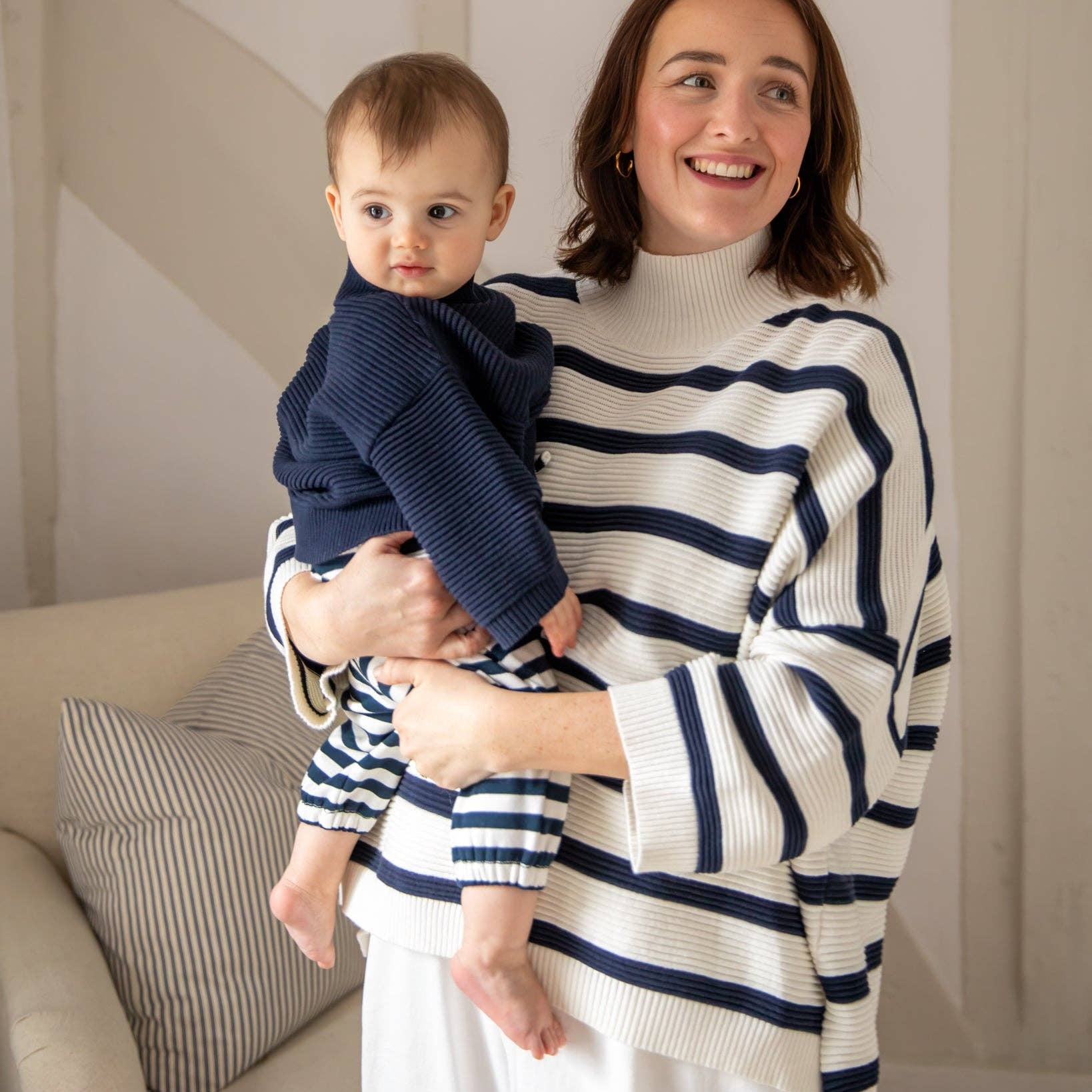 Woman holding a baby in a living room setting