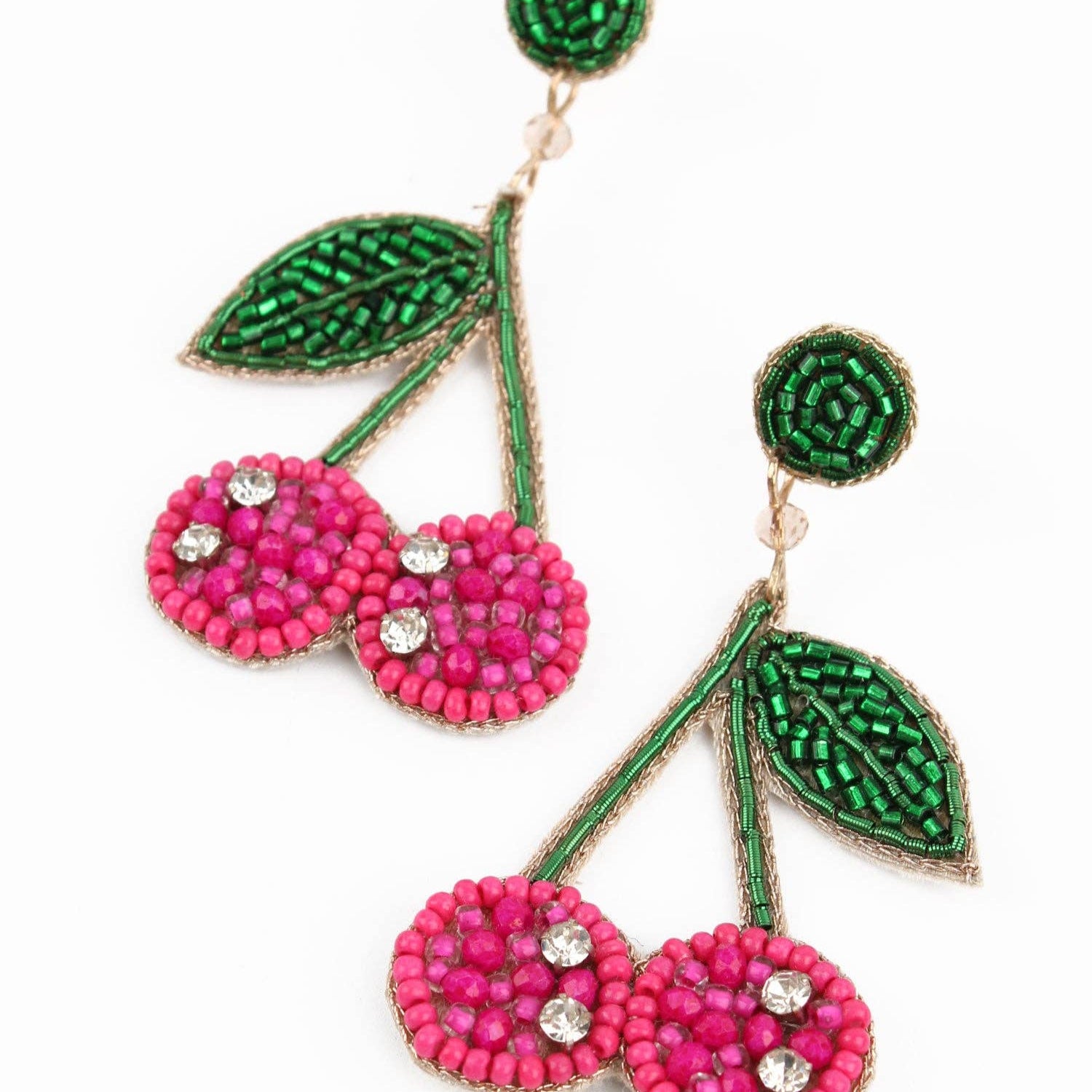 Cherry-themed earrings with pink beads and green leaves on a white background