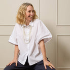 Woman wearing a white blouse with a neutral background