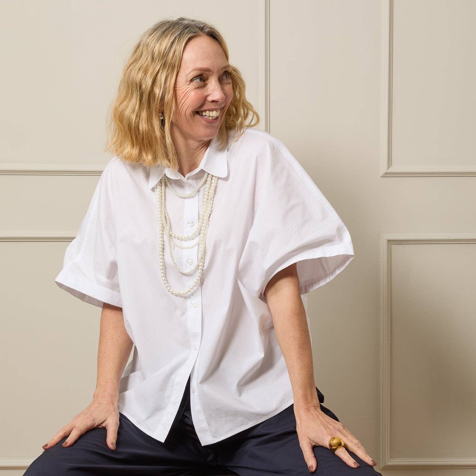 Woman wearing a white blouse with a neutral background