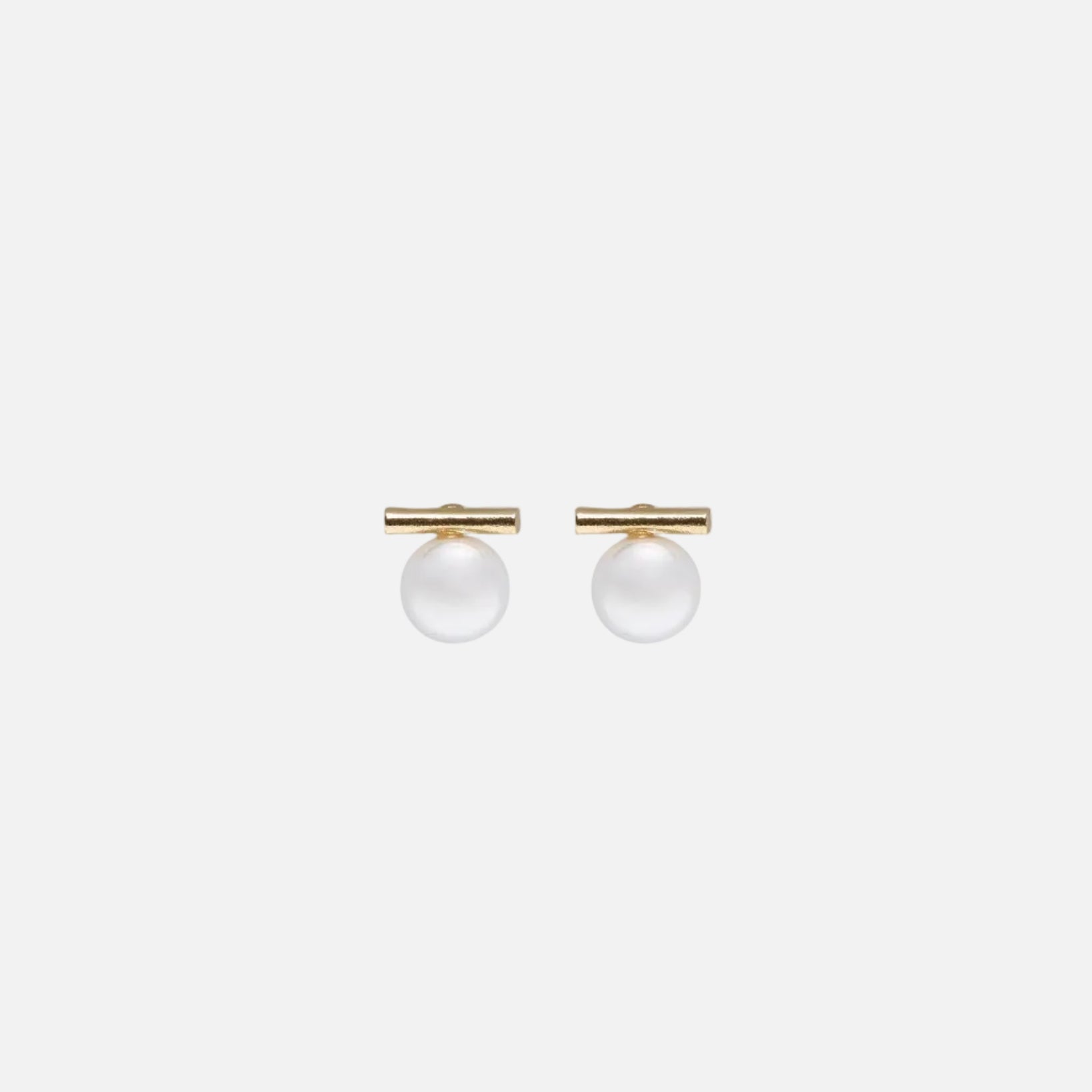 Pair of gold earrings with spherical pearls on a white background