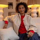 Woman sitting on a couchwearing pearl earrings.