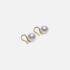 Pair of pearl earrings with gold hooks on a white background