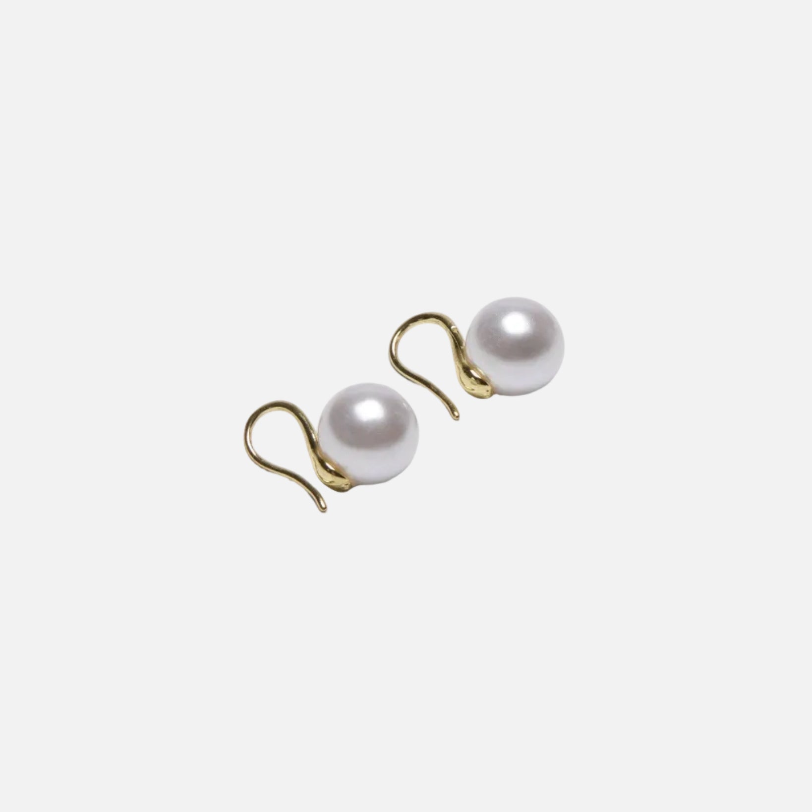 Pair of pearl earrings with gold hooks on a white background