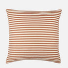Striped pillow with brown and white stripes on a white background