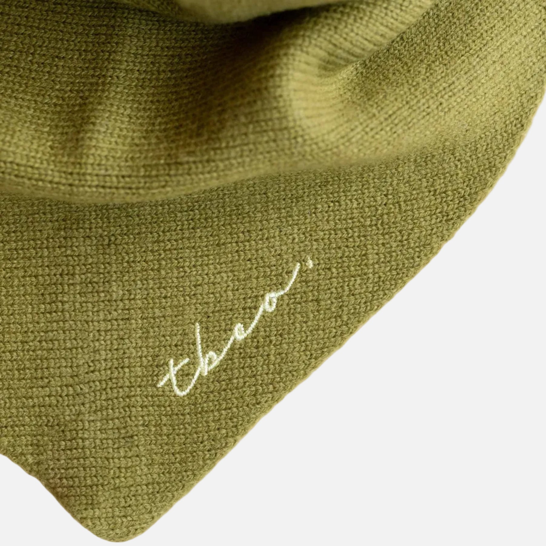 Olive green triangle scarf - close up showing TBCo logo