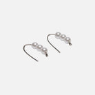 Three pearls on a drop earring silver on a white background