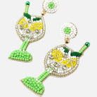 Pair of beaded earrings with green, yellow, and white design on a white background