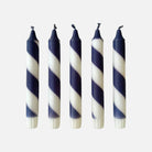 Five navy and white striped candles on a white background