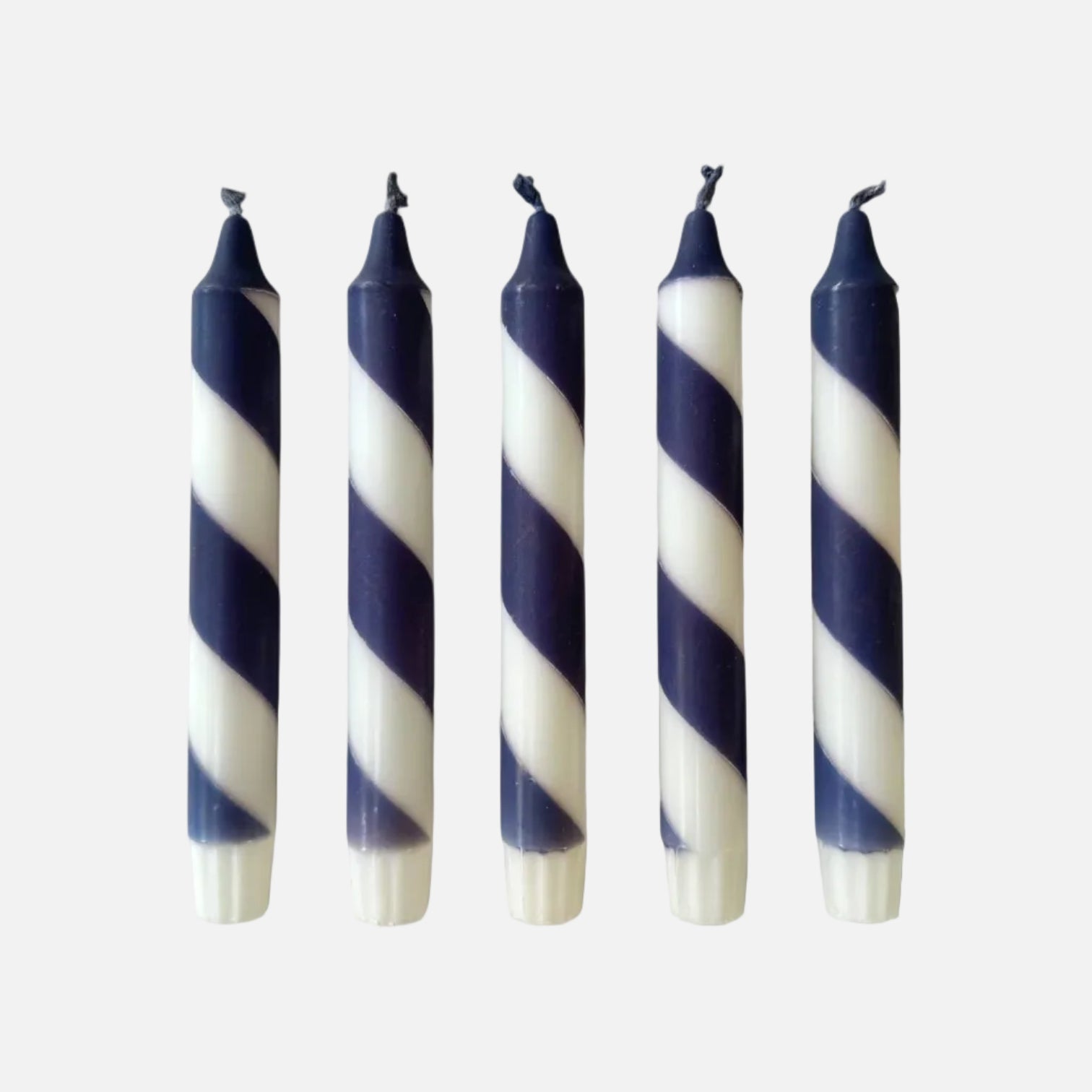 Five navy and white striped candles on a white background